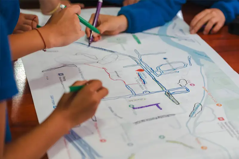 Students drawing on a road map